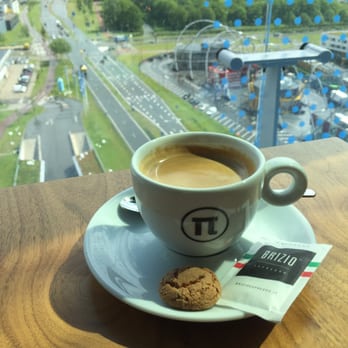 Brizio espresso met uitzicht, geserveerd met een amandelkoekje voor een stijlvol koffiemoment.