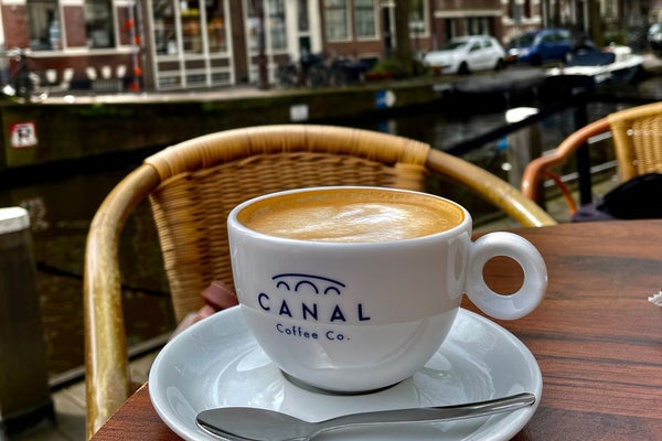 Geniet van een kop Canal Coffee Co. aan de Amsterdamse grachten – vers gebrand, cafékwaliteit.