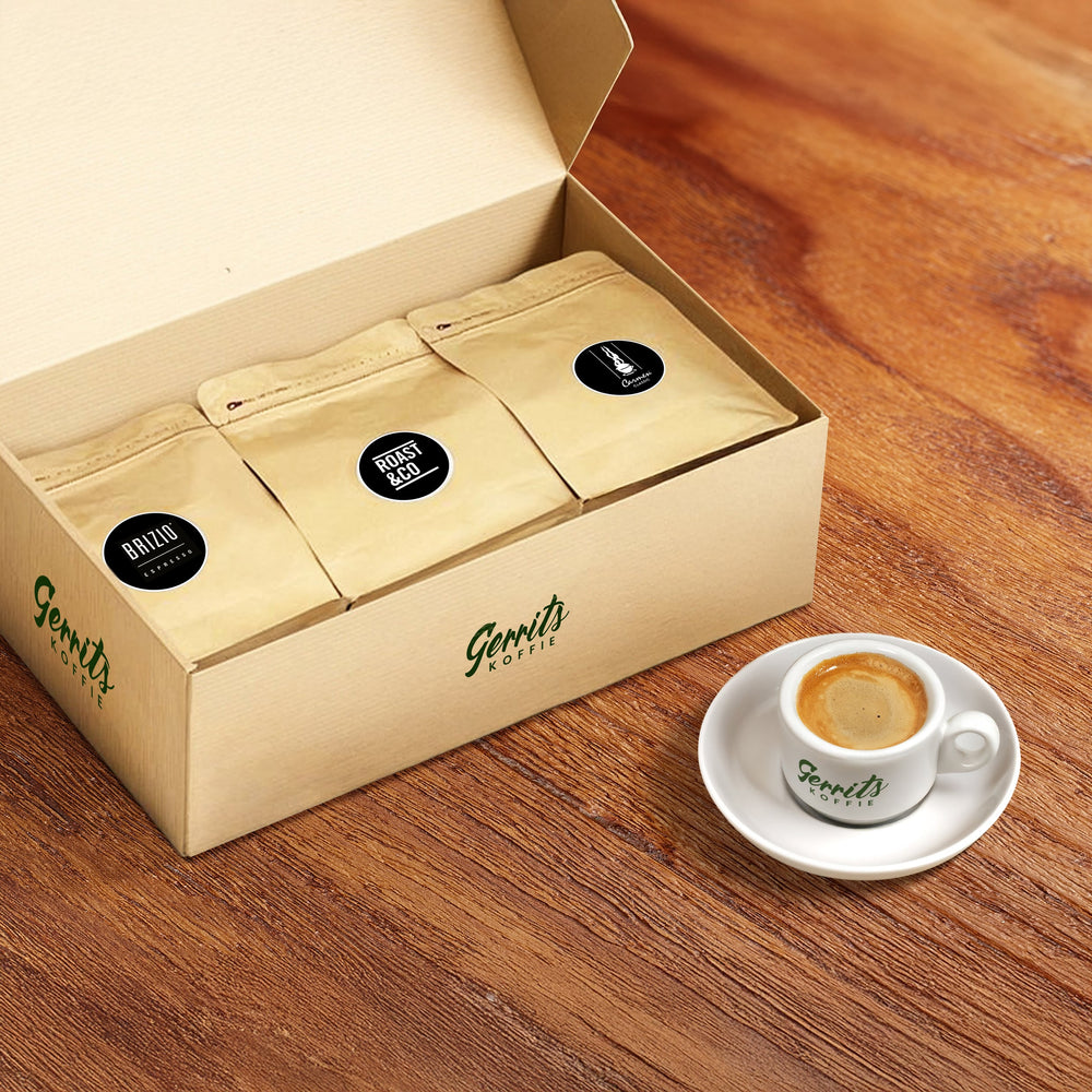 Espresso proefpakket met drie zakjes koffie in een doos en een vers kopje espresso op houten tafel