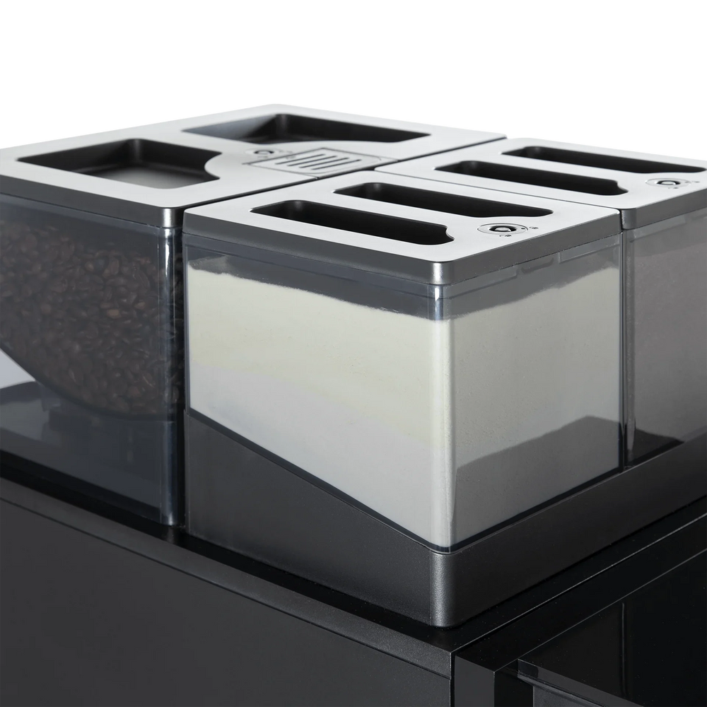 Gerrits Koffie Melkpoeder in a clear container, part of a coffee station setup.